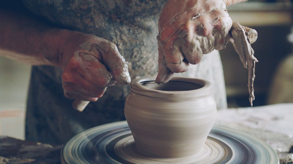 Artisan shaping clay on a wheel